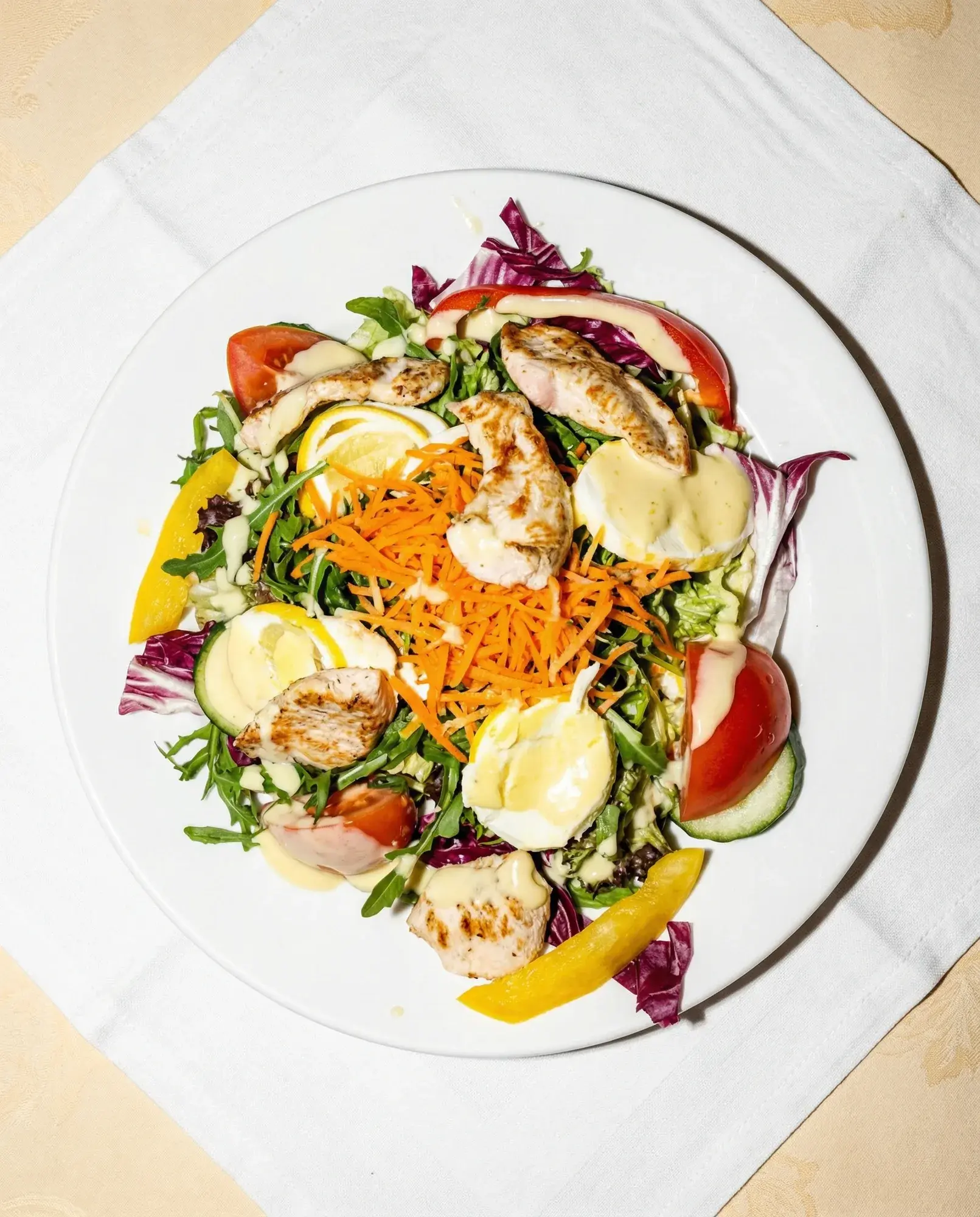 Frischer Salat von oben auf hellem Tisch bei La Commedia.