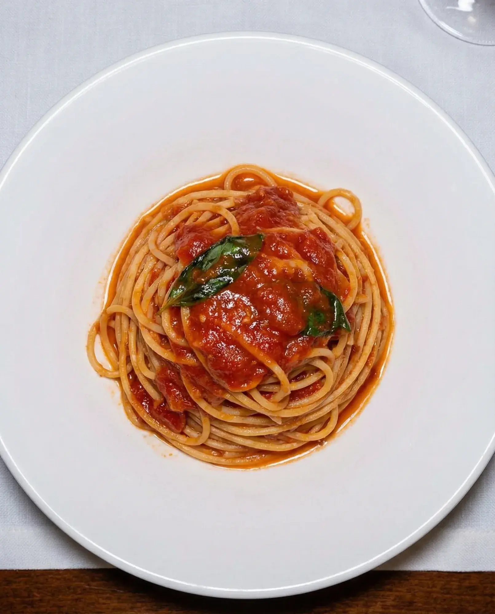 Spaghetti Napoli von oben auf hellem Tisch bei La Commedia.